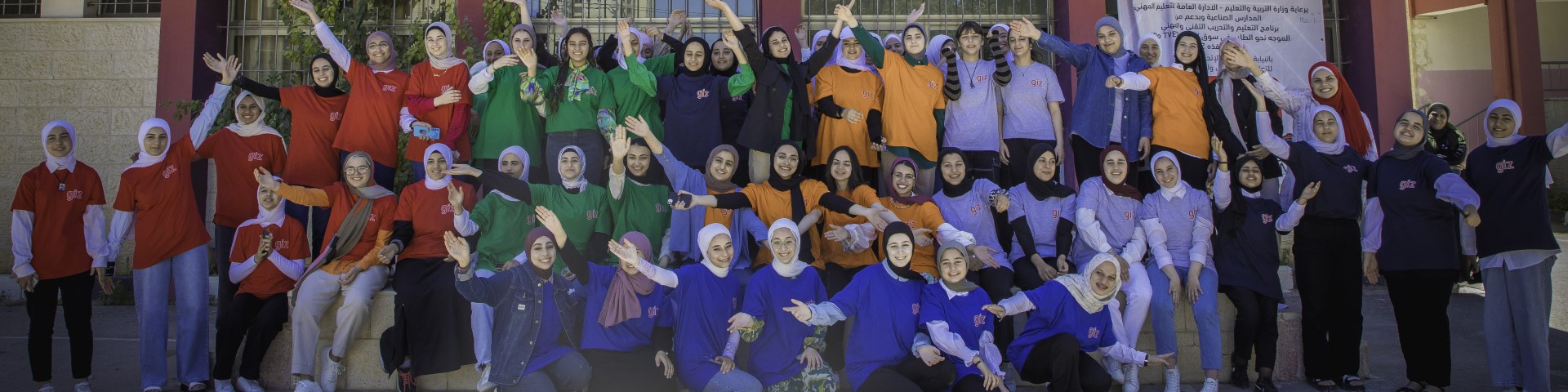 Gruppenfoto von jungen Frauen vor einer Berufsschule