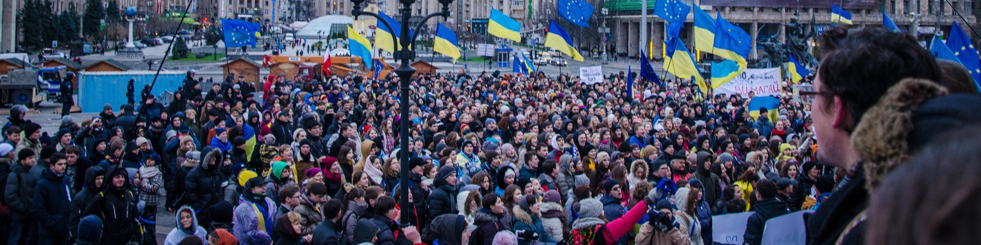 Menschenmenge mit Flaggen der Ukraine und der Europäischen Union.