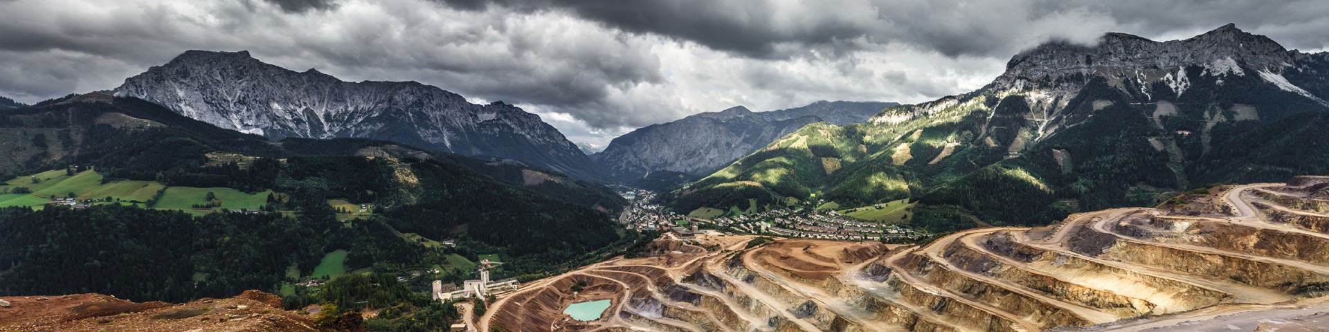 Eine bergige Landschaft mit einem Bergbaugebiet im Vordergrund.