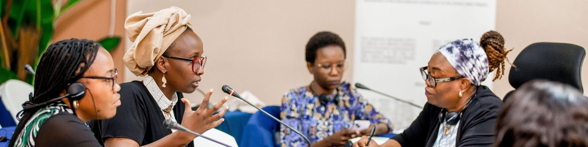 Vier Frauen sitzen bei einer Veranstaltung der Internationalen Konferenz der Region der Großen Seen (ICGLR) an einem Tisch mit Mikrofonen.