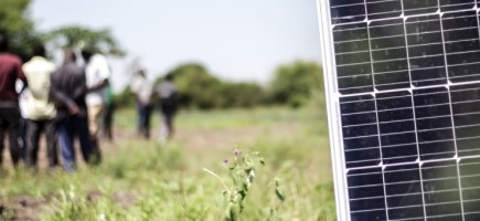  Ein Solarpanel mit einer Menschengruppe im Hintergrund.