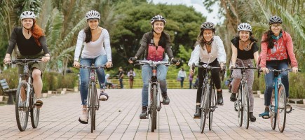  Mehrere Personen fahren lächelnd nebeneinander Fahrrad.