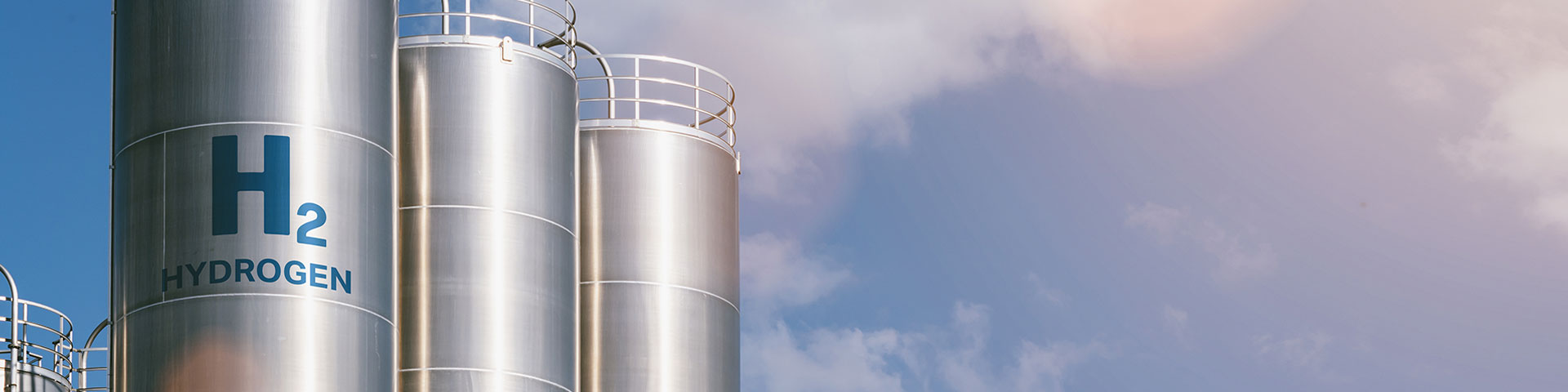 Three silver cylinders at a green hydrogen factory.