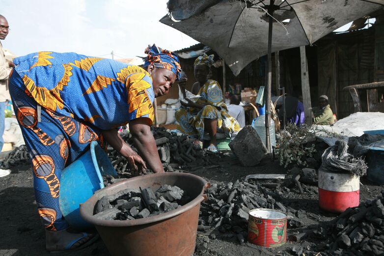 A woman sells charcoal at the market.