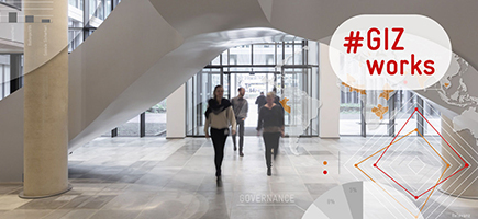 People in an entrance hall. The GIZ logo is on the tile.