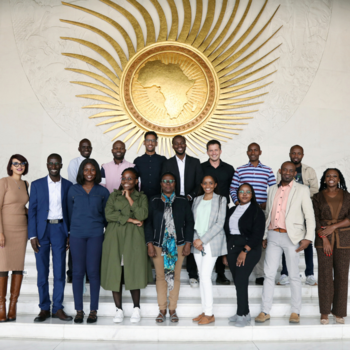 AU Media Fellows standing in two rows at the headquarters of the African Union Commission.