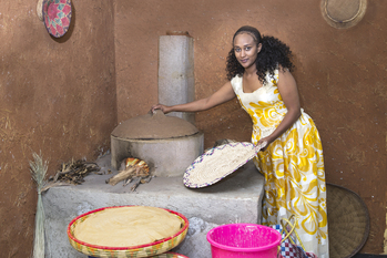 A woman in Ethiopia cooking traditional food using an energy-efficient stove.