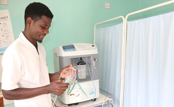 A health worker at a hospital supported by GIZ Malawi installing an oxygen cylinder.