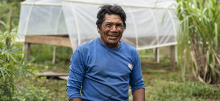 A cacay nut farmer in front of a nut collection point.