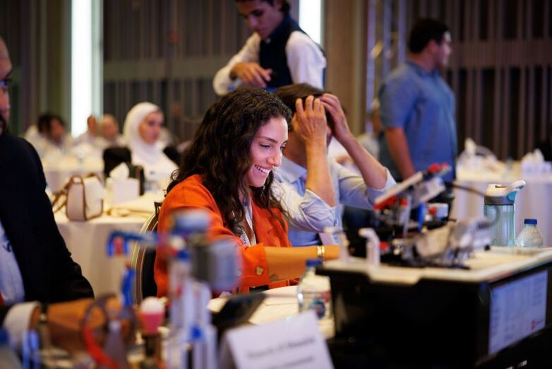 A jury sitting at a table listening to pitches by companies while prototypes are presented.