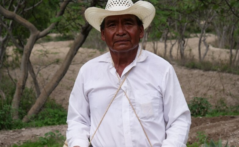 Un agricultor de Hidalgo, México, con cestas tejidas llenas de maíz y frijoles.