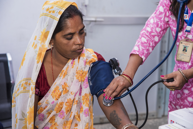 A woman has her blood pressure taken by a doctor.