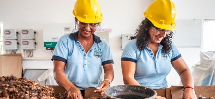 Two women in hard hats selecting seeds.