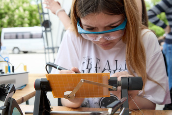 A woman practices soldering