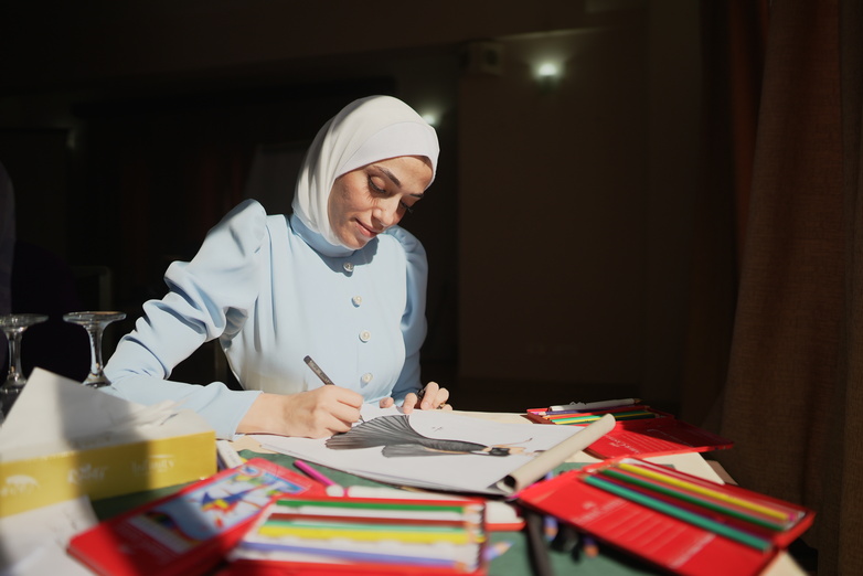 A young woman sketching a fashion design.