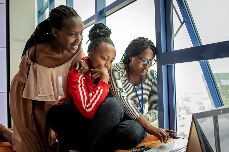 Three women look at a screen during an IT training session.