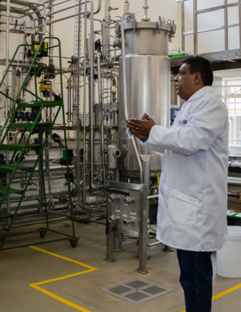 A trainer stands in a biotechnological production facility.