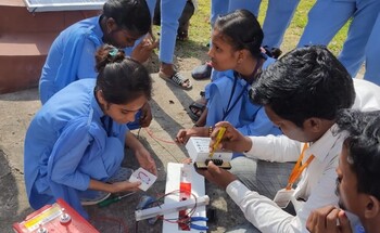 A group of trainees works together on an outdoor electrical wiring task, practicing hands-on skills.