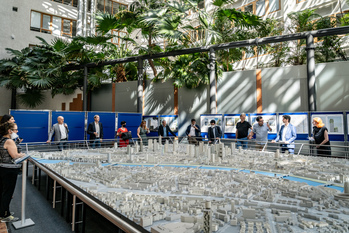 People standing around a model of a city.