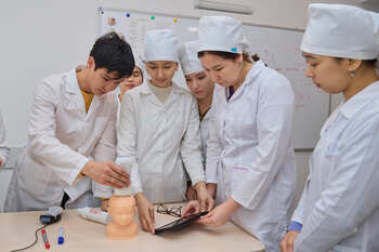 A man trains healthcare staff to examine newborn babies.