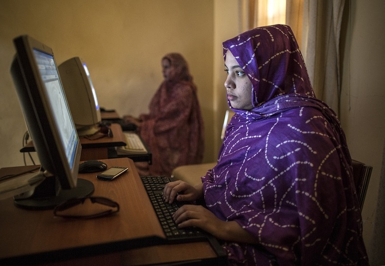 Women sitting at computer screens.