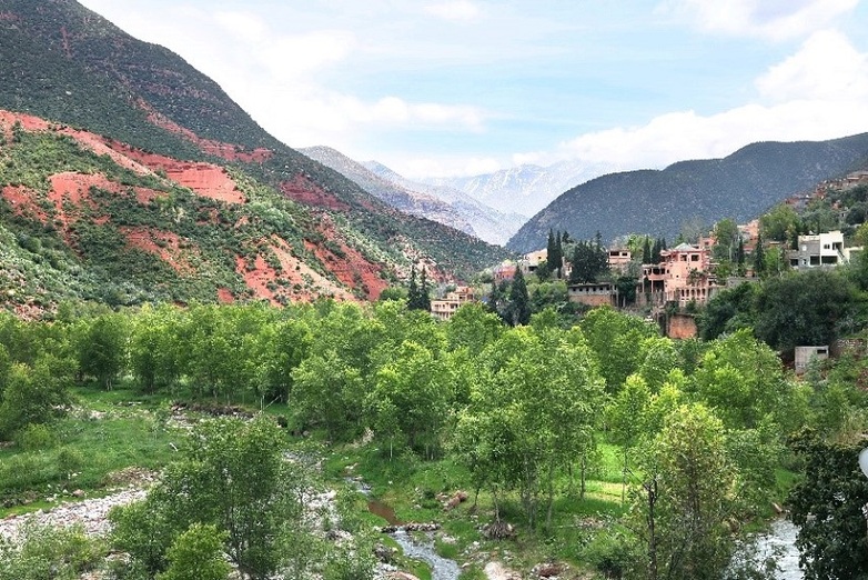 A city and river against a mountainous background.