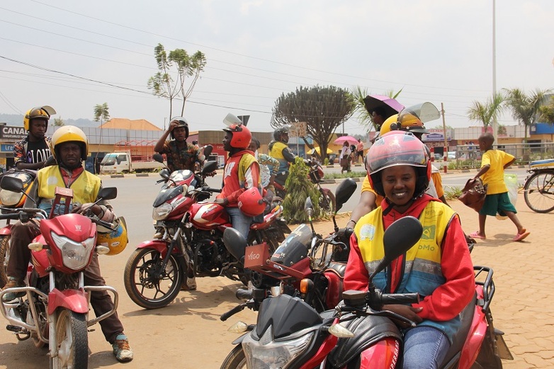 A group of motorcycle drivers is standing at the side of the road