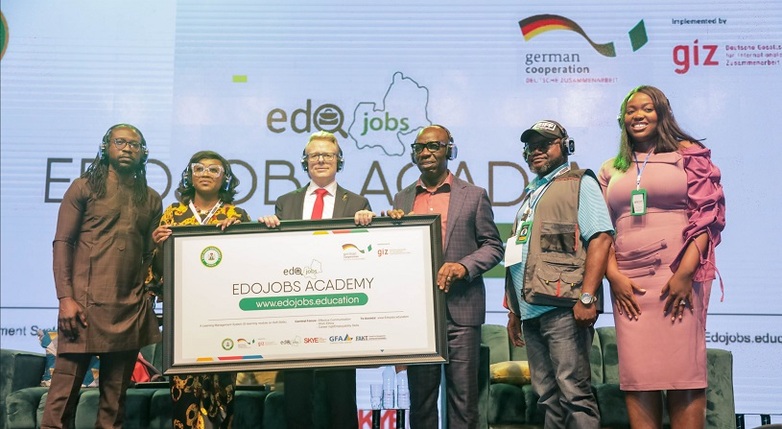 Six people with a poster for the Edo Jobs online Academy at its launch on a stage.