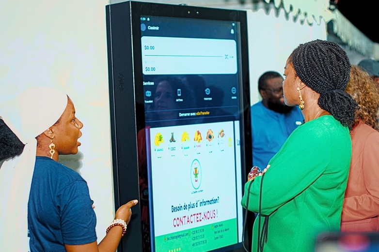 Women are looking at a large digital display.