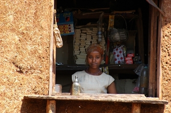 A young woman looks out of a kiosk