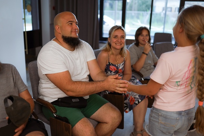 A veteran holding his daughter's hand during a family therapy session