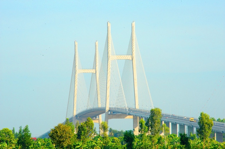 Distant view of a large suspension bridge in the Mekong Delta