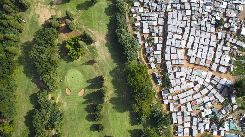 A poor neighbourhood next to a golf course