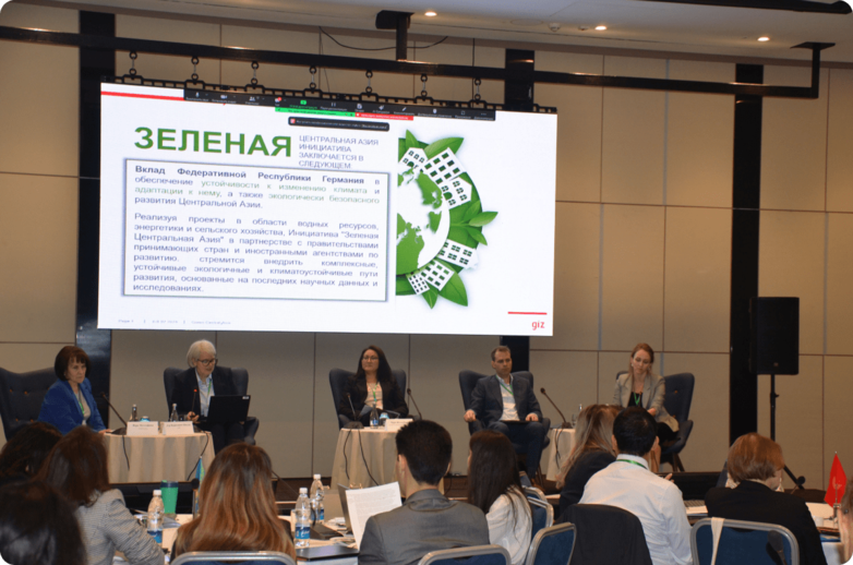 Several people sit on a stage in front of a presentation.