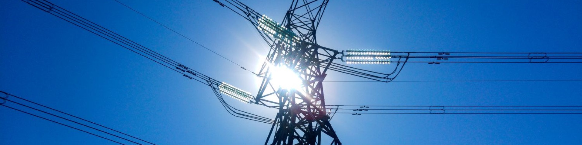 High voltage power line stretching across clear blue sky.