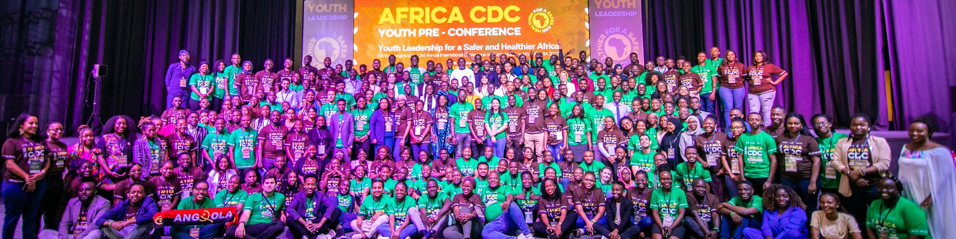 A large group of participants at the Africa CDC Youth Pre-Conference, focused on Youth Leadership for a Safer and Healthier Africa, posing together on stage.