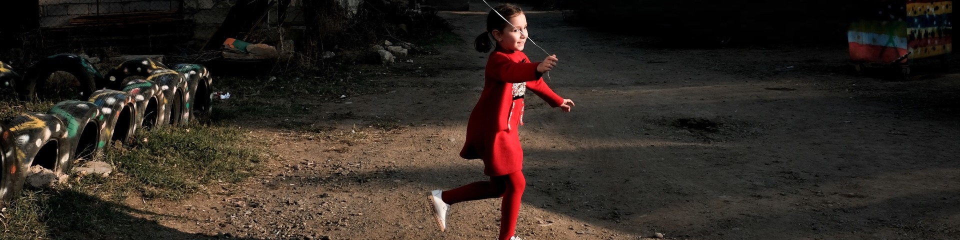 A young girl plays outside with a balloon.