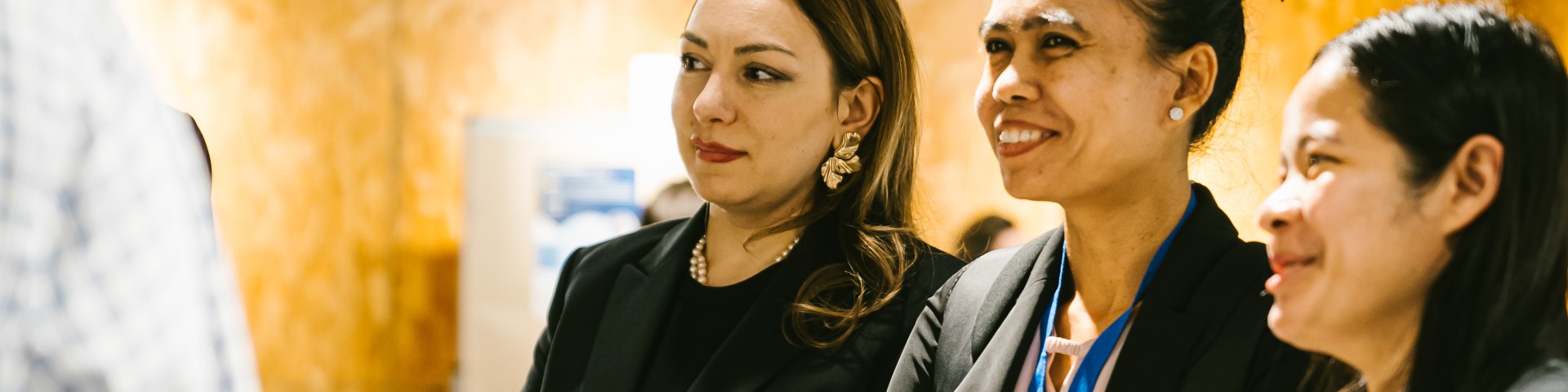 Three women standing next to each other at a workshop.