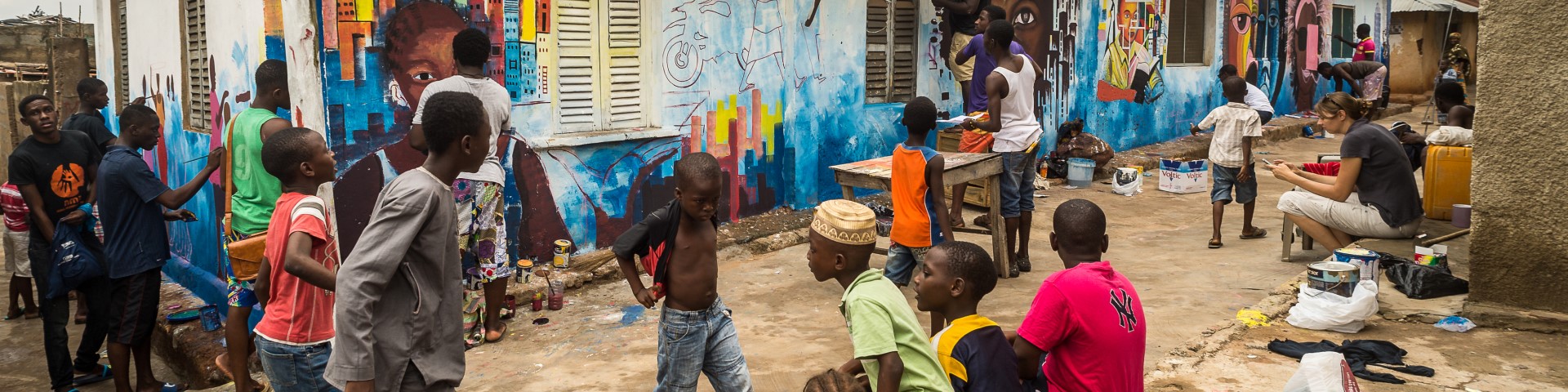 People sit and walk in streets filled with art.