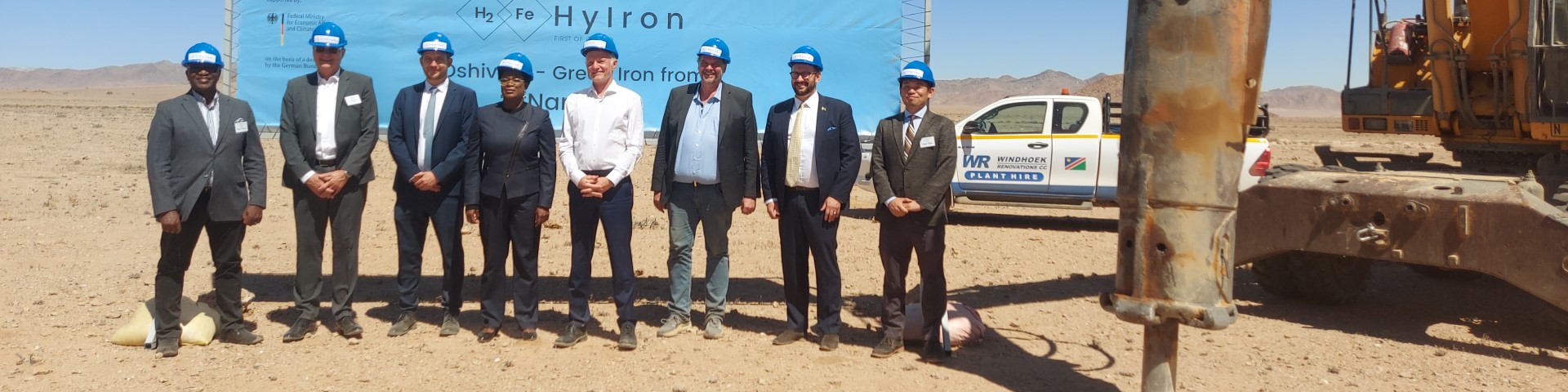 Men stand in a group at the inauguration of a project on green iron production in Namibia.