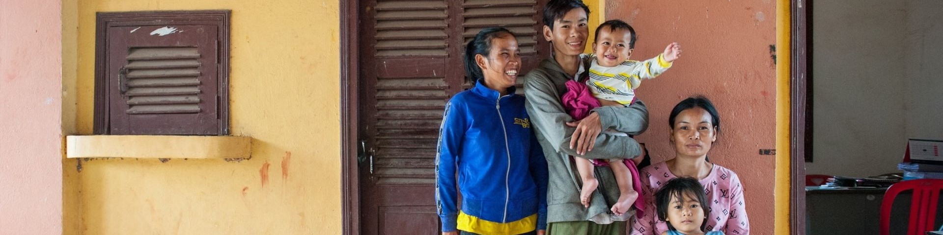 Three adults and two children smiling at the camera.