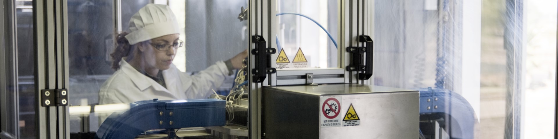 Une personne en blouse de laboratoire travaillant sur une machine.