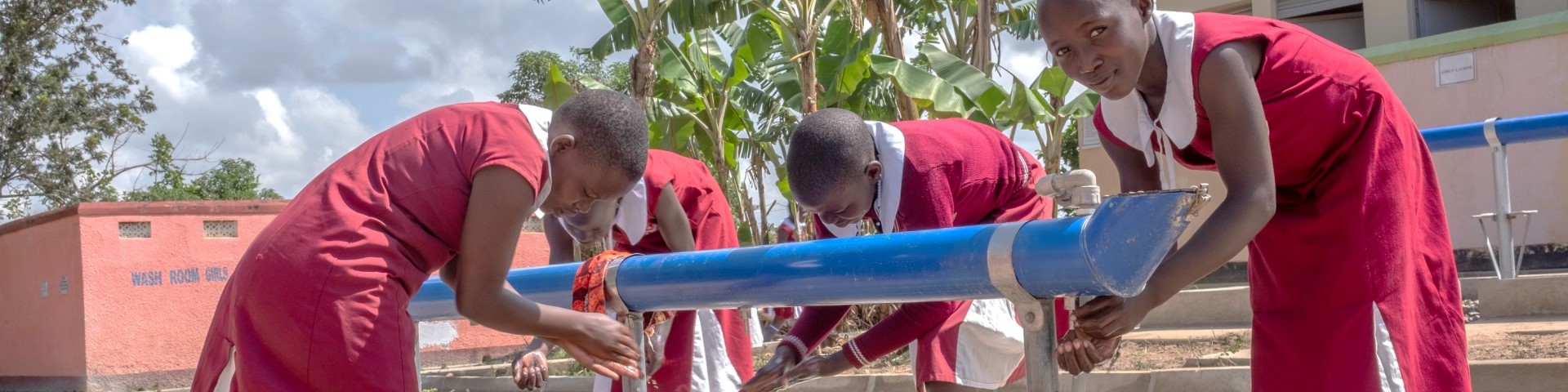 Ugandan schoolgirls wash their hands at a WASHaLOT