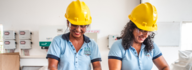 Two women in hard hats selecting seeds.