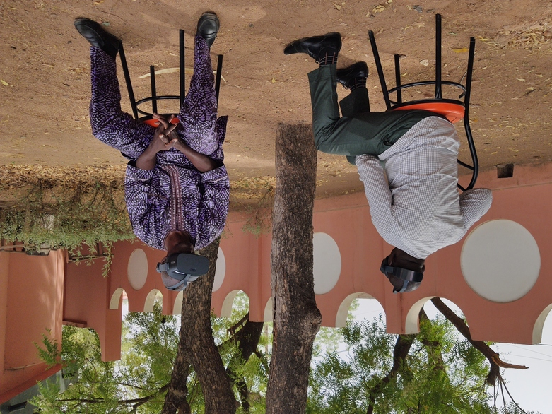 Au Cameroun, deux hommes portent un casque de réalité virtuelle lors d'une formation à la culture durable du coton.