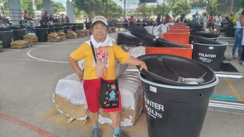 A smallholder standing next to equipment for a breeding centre for small animals.