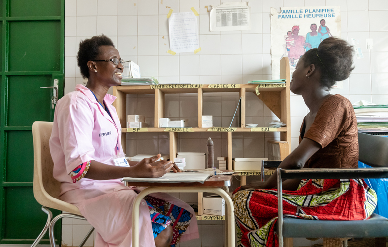 A doctor conducts a consultation with a woman at a health centre.