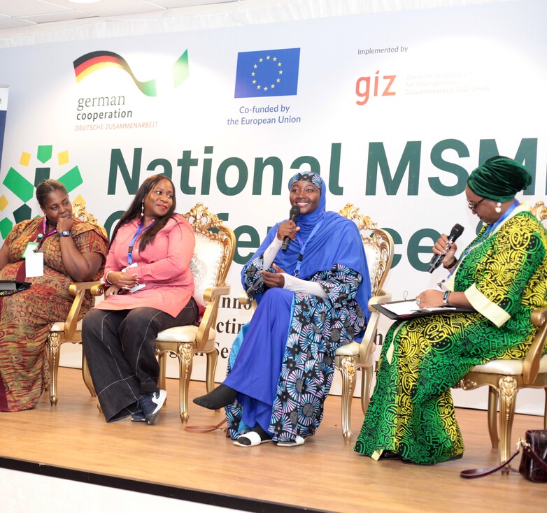 Women on a stage, sitting in a round table and sharing their thoughts.