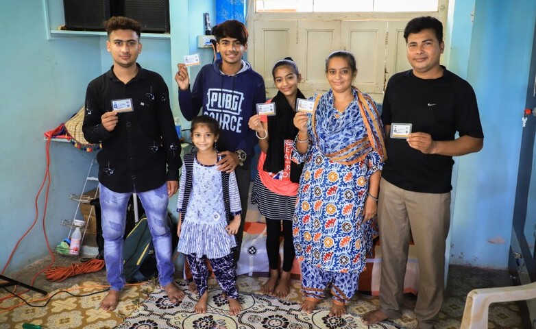 An Indian family proudly displays their Ayushman cards.