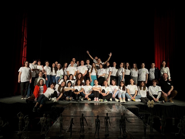 A group of young people pose on a stage.